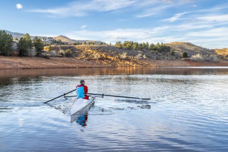 Téléchargez les photos : Rameur mâle senior ramer une coquille d'aviron côtière - Horsetooth réservoir en automne ou en hiver paysages dans le nord du Colorado. - en image libre de droit