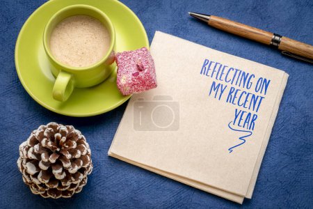 Foto de Reflexionando sobre mi reciente año - una nota en una servilleta con café, final de año expeince personal y revisión de la historia - Imagen libre de derechos