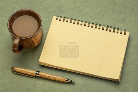 Téléchargez les photos : Carnet de croquis en spirale vierge contre papier texturé avec une tasse de café, bureau plat laïc - en image libre de droit
