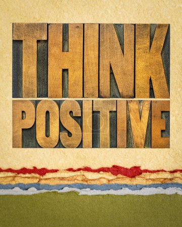 Foto de Piensa positivamente - palabra abstracta en tipografía vintage bloques de madera sobre papel de arte, optimismo y concepto de mentalidad - Imagen libre de derechos