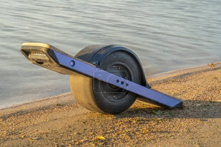 Photo for One-wheeled electric skateboard (personal transporter) on a lake shore in Colorado - Royalty Free Image