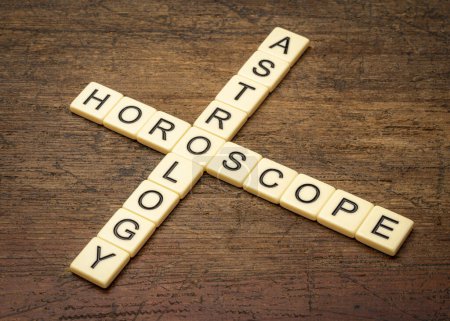 Photo for Astrology and horoscope crossword in ivory letter tiles against rustic weathered wood - Royalty Free Image