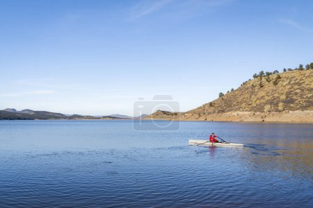 Téléchargez les photos : Rameur mâle senior ramer une coquille d'aviron côtière Carter en automne ou en hiver paysages dans le nord du Colorado. - en image libre de droit