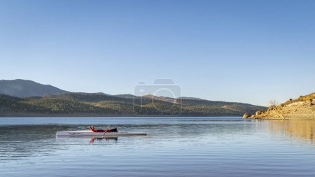 Téléchargez les photos : Rameur mâle se repose dans sa coquille d'aviron sur le lac Carter en automne ou en hiver paysages dans le nord du Colorado - en image libre de droit