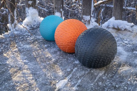 Téléchargez les photos : Balles de slam lourds remplis de sable sur un pont arrière glacé, exercice et concept de fitness fonctionnel - en image libre de droit