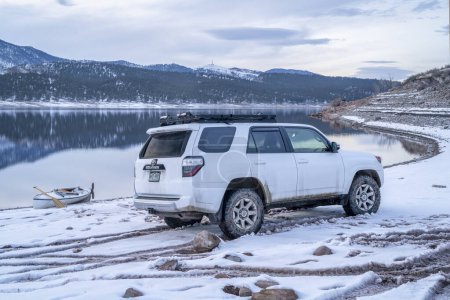 Téléchargez les photos : Loveland, CO, USA - 5 février 2024 : Toyota 4Runner SUV et un canot d'expédition sur une rive du lac Carter dans le nord du Colorado au crépuscule après un voyage de pagaie. - en image libre de droit