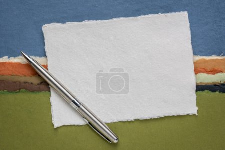 Téléchargez les photos : Petite feuille de papier blanc blanc blanc Khadi chiffon de l'Inde contre paysage abstrait avec un stylo - en image libre de droit