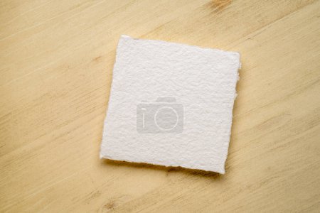 Foto de Hoja pequeña, cuadrada, en blanco de papel de acuarela contra fondo de madera - Imagen libre de derechos