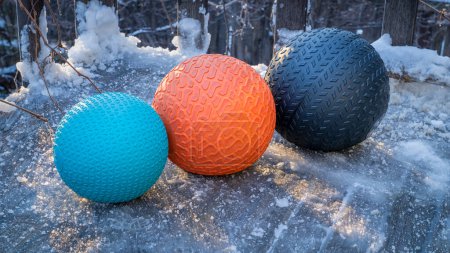 Téléchargez les photos : Balles de slam lourds remplis de sable sur un pont arrière glacé, exercice et concept de fitness fonctionnel - en image libre de droit
