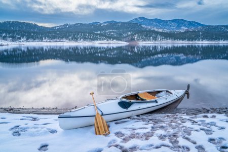 Foto de Después de remar paisaje, canoa de expedición en una orilla del lago Carter en el norte de Colorado al atardecer de invierno - Imagen libre de derechos