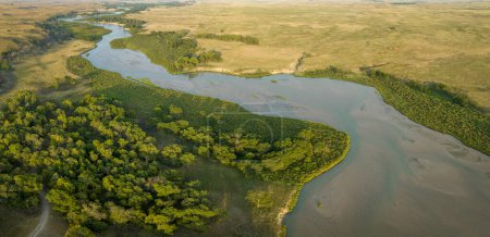 Luftaufnahme des düsteren Flusses, der sich durch Nebraska Sandhills im Nebraska National Forest schlängelt, spätsommerliche Landschaft