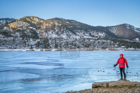 Téléchargez les photos : Randonneur masculin avec bâtons de trekking sur une rive de réservoir Horsetooth gelé près de Fort Collins, Colorado concept de randonnée d'hiver - en image libre de droit