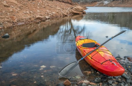 Foto de Colorido río kayak en una costa rocosa de lago de montaña - concepto de recreación - Imagen libre de derechos