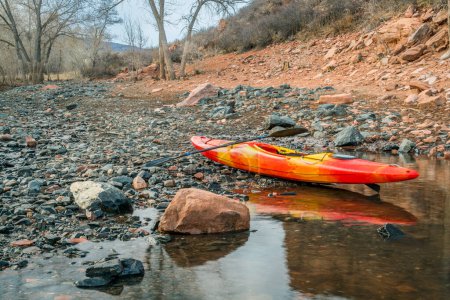 colorful river kayak on a rocky shore of mountain lake - recreation concept