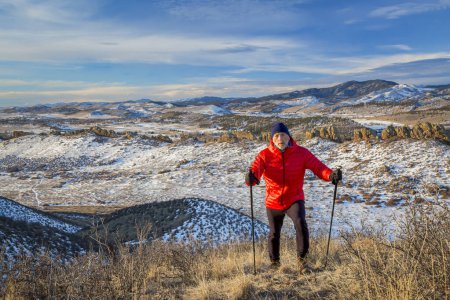 Senior männlicher Wanderer erreicht Gipfel eines Hügels am Fuße der felsigen Berge - Winterlandschaft an Teufels Rückgrat Freifläche in der Nähe von Loveland, colorado