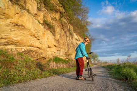 Photo for Senior male cyclist riding a folding bike on Steamboat Trace, bike trail converted from an abandoned railroad, near Peru, Nebraska, springtime morning scenery - Royalty Free Image