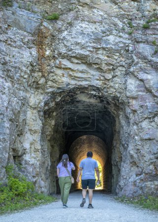 Téléchargez les photos : Rocheport, MO, États-Unis - 21 avril 2024 : Un couple traverse le tunnel MKT sur Katy Trail. Le Katy Trail est une piste cyclable de 237 miles qui s'étend sur la majeure partie de l'État du Missouri converti d'un ancien chemin de fer. - en image libre de droit