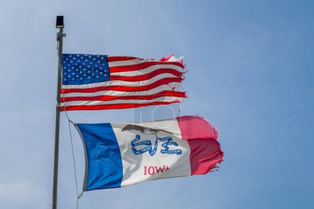 Drapeaux américains et de l'État de l'Iowa agitant fièrement et flottant sur un vent fort