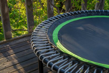 mini trampoline for fitness exercising and rebounding in a backyard patio, spring scenery