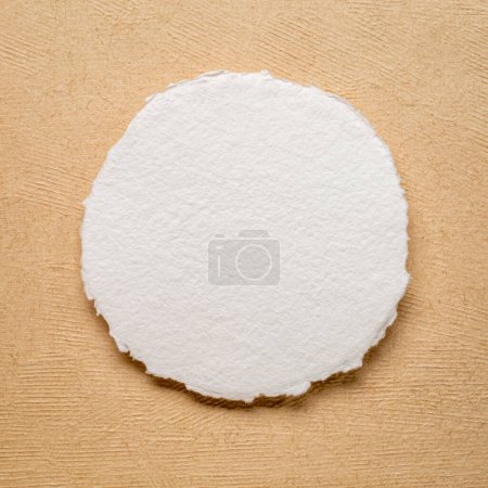 kreisförmiges Blatt weißen Aquarellpapiers gegen handgeschöpftes amatfarbenes Rindenpapier