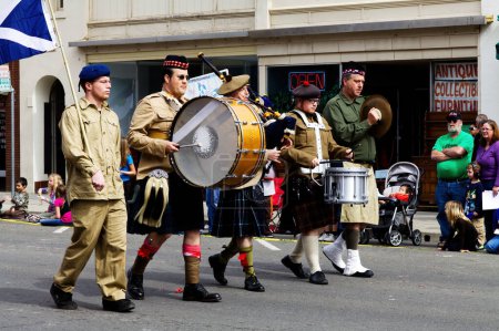 Photo for Men Marching In Parade In Yuba City California Wearing Kilts And Playing Bagpipes And Drums - Royalty Free Image