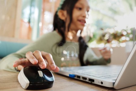 Photo for Southeast Asian teen girl smiling communicate with friend through internet using laptop in a restaurant - Royalty Free Image