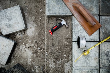 Blick von oben auf Pflastersteinbodenarbeiten mit Werkzeug