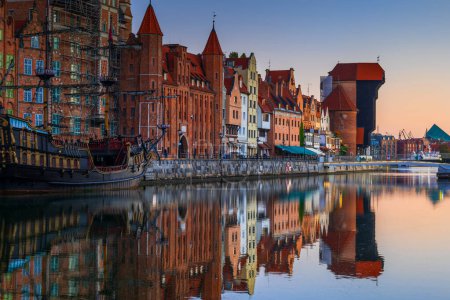 City of Gdansk at dawn in Poland. Skyline of the Old Town along Long Embankment street with reflection in Motlawa River.