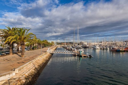 Resort town of Lagos, in Algarve region, Portugal marina and promenade lined with palm trees.