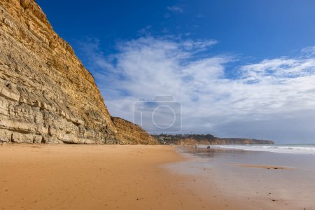 Praia de Porto Mos sandy beach and cliff in Lagos, resort town on Algarve coast in Faro District, southern Portugal.
