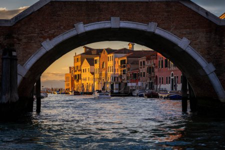City of Venice at sunset in Italy, arch of Ponte dei Tre Archi bridge across Cannaregio Canal.