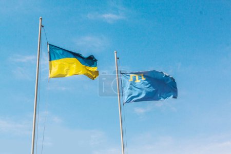 Téléchargez les photos : Drapeau volant de l'Ukraine et la Crimée dans le ciel bleu. Symboles d'État de l'Ukraine - en image libre de droit
