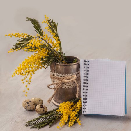 Téléchargez les photos : Composition de Pâques avec les oeufs et le mimosa sur un notebook de page de fond propre - en image libre de droit