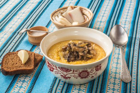Téléchargez les photos : Porridge de maïs - banosh au bacon grillé, oignons, pain de seigle au poivre et au bacon, ail et champignons. - en image libre de droit