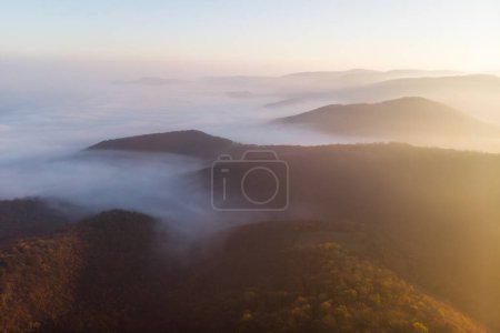 Téléchargez les photos : Lever de soleil majestueux sur la chaîne de montagnes brumeuse Visegradi en Hongrie. Drone tirer tôt le matin. - en image libre de droit