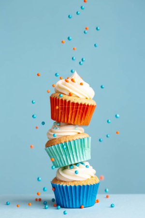 Photo for Sugar sprinkles falling on stack of colorful cupcakes - Royalty Free Image