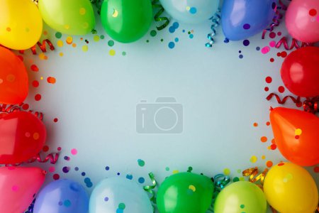 Birthday party background with rainbow border of colorful party balloons with streamers and confetti