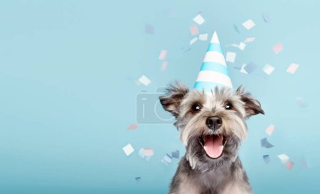 Foto de Lindo perro feliz celebrando en una fiesta de cumpleaños, usando un sombrero de fiesta con confeti cayendo - Imagen libre de derechos