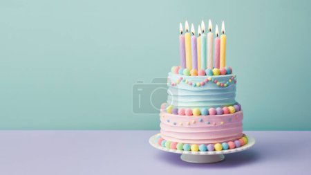 Foto de Pastel de cumpleaños con gradas de color pastel decorado con caramelos y velas de colores con glaseado de crema de mantequilla pastel sobre un fondo turquesa liso - Imagen libre de derechos