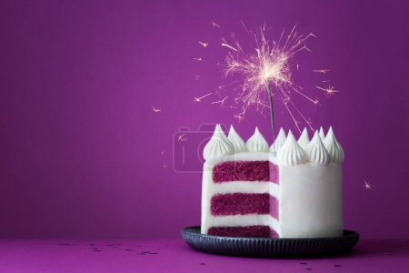 Foto de Pastel de capa de celebración de cumpleaños púrpura con glaseado blanco y espumoso de celebración sobre un fondo púrpura - Imagen libre de derechos