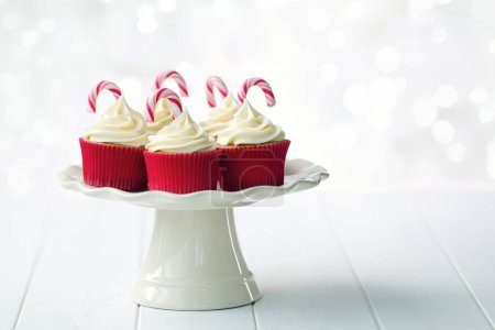 Foto de Pastelitos de Navidad decorados con glaseado blanco y bastones de caramelo de Navidad - Imagen libre de derechos