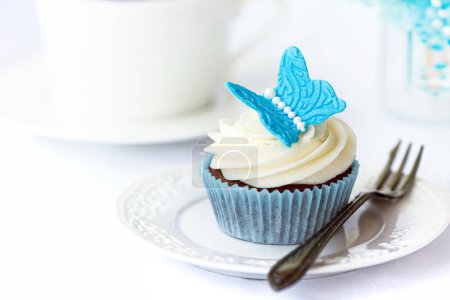 Téléchargez les photos : Cupcake décoré d'un papillon fondant bleu - en image libre de droit