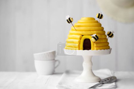Photo for Beehive birthday cake with yellow buttercream and sugarpaste bees - Royalty Free Image