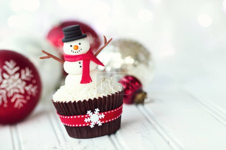 Téléchargez les photos : Cupcake de Noël décoré d'un bonhomme de neige fondant - en image libre de droit