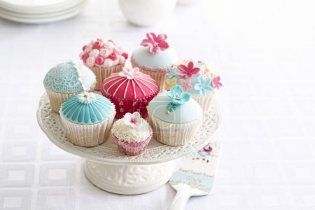 Téléchargez les photos : Thé de l'après-midi servi avec une variété de cupcakes - en image libre de droit