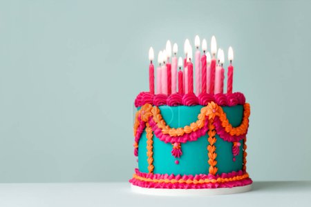 Aufwendige jadefarbene Geburtstagstorte mit rosa und orangefarbenen Paspelschnörkeln im Vintage-Stil und Geburtstagskerzen