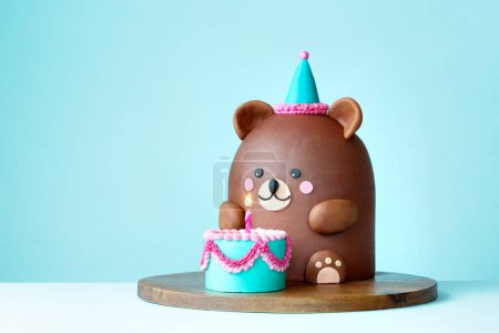 Cute teddy bear birthday cake with mini birthday cake and one birthday candle