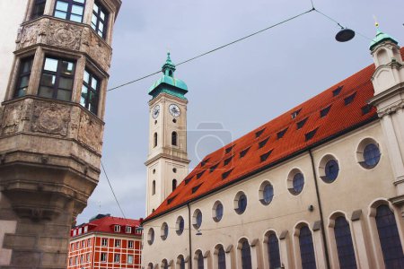 Balcón del edificio de la Stadtsparkasse Munich (izquierda) e Iglesia del Espíritu Santo (derecha), Munich, Alemania