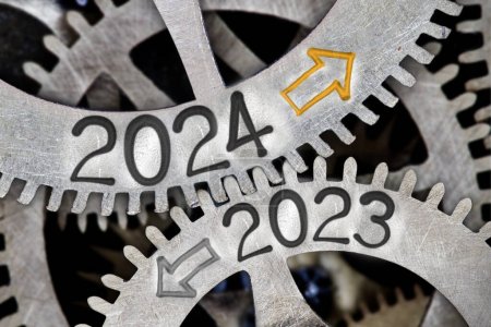 Photo for Photo of tooth wheel mechanism with numbers 2024 and 2023 and arrows imprinted on metal surface. New Year concept. - Royalty Free Image