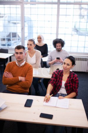 Foto de Estudiantes multiétnicos que escuchan a un profesor en un aula. Jóvenes inteligentes estudian en una universidad. - Imagen libre de derechos